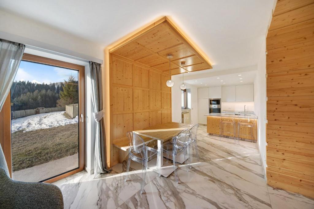 a kitchen with a table and a large window at Roda A Parte in Vigo di Fassa