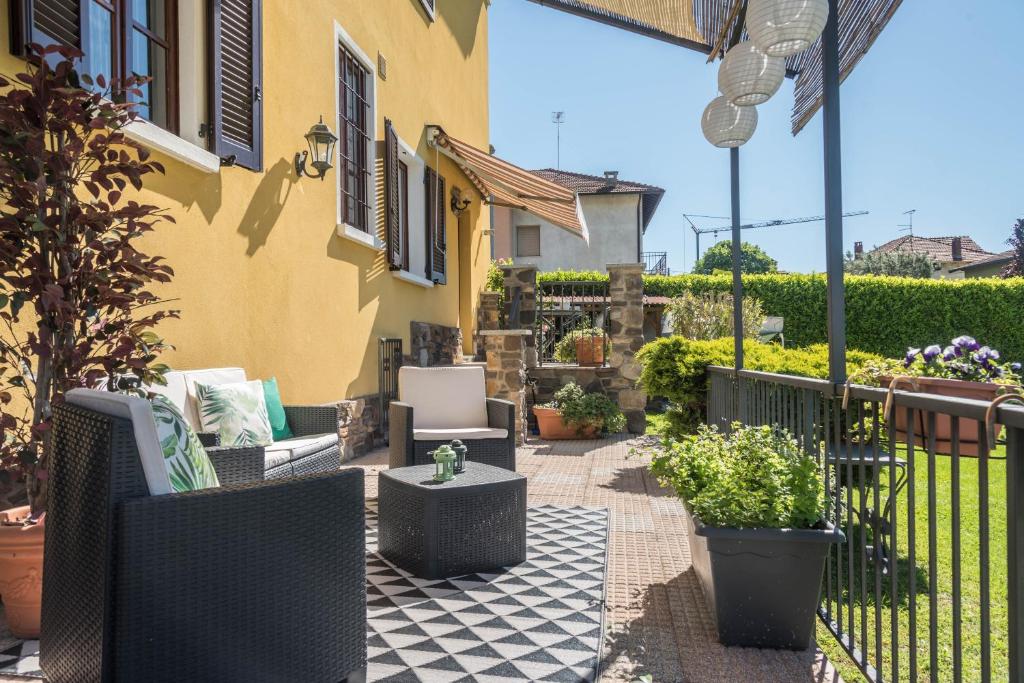 a patio with chairs and plants and a fence at Tinas yellow home in Leggiuno