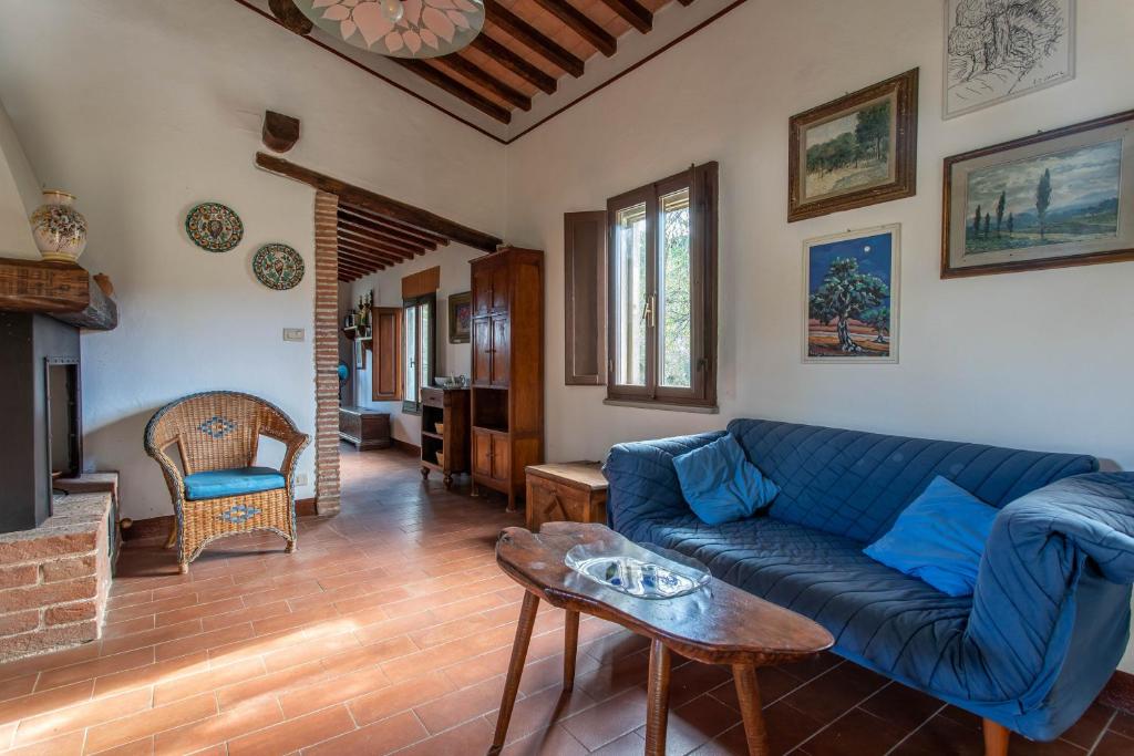 a living room with a blue couch and a table at La Casa dei Mandorli in Talamone
