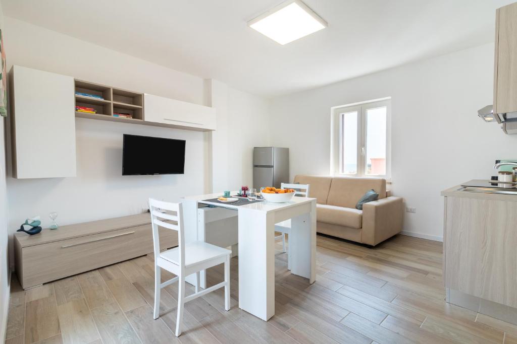 a kitchen and living room with a white table and chairs at Suite N12 - Luxury Apartment in Bari