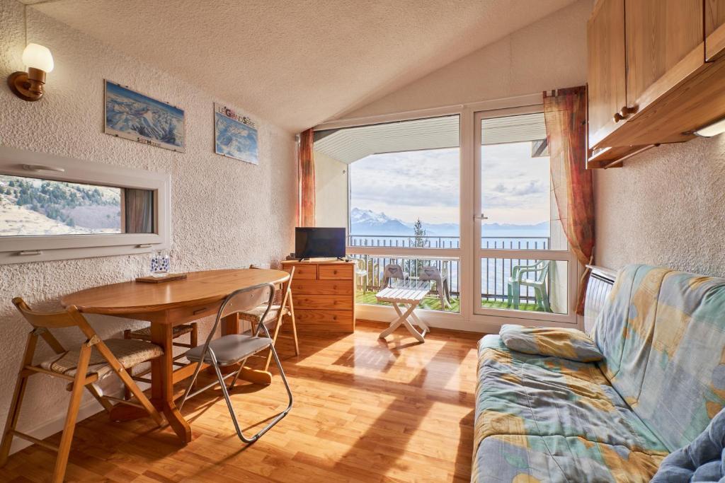 a bedroom with a desk and a table with a tablektop at Appartement Avec Balcon St Honore in Saint-Honoré