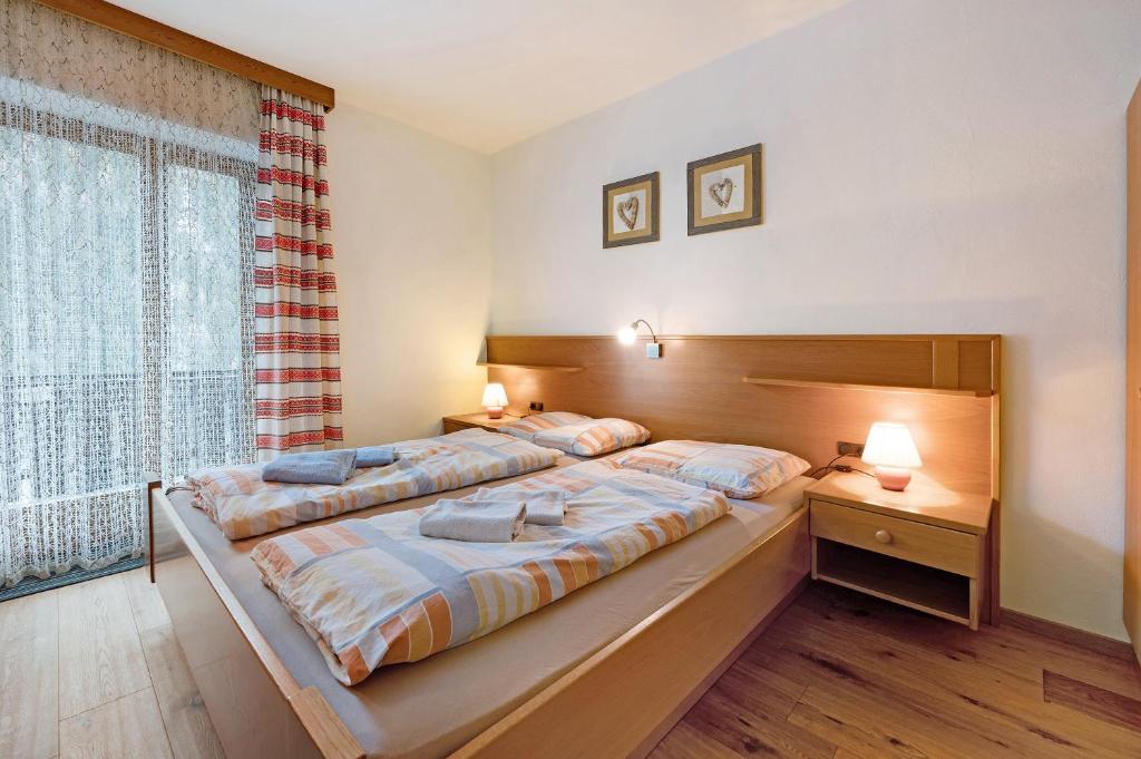 a large bedroom with two beds and a large window at Heiserhof App Holunder in Racines