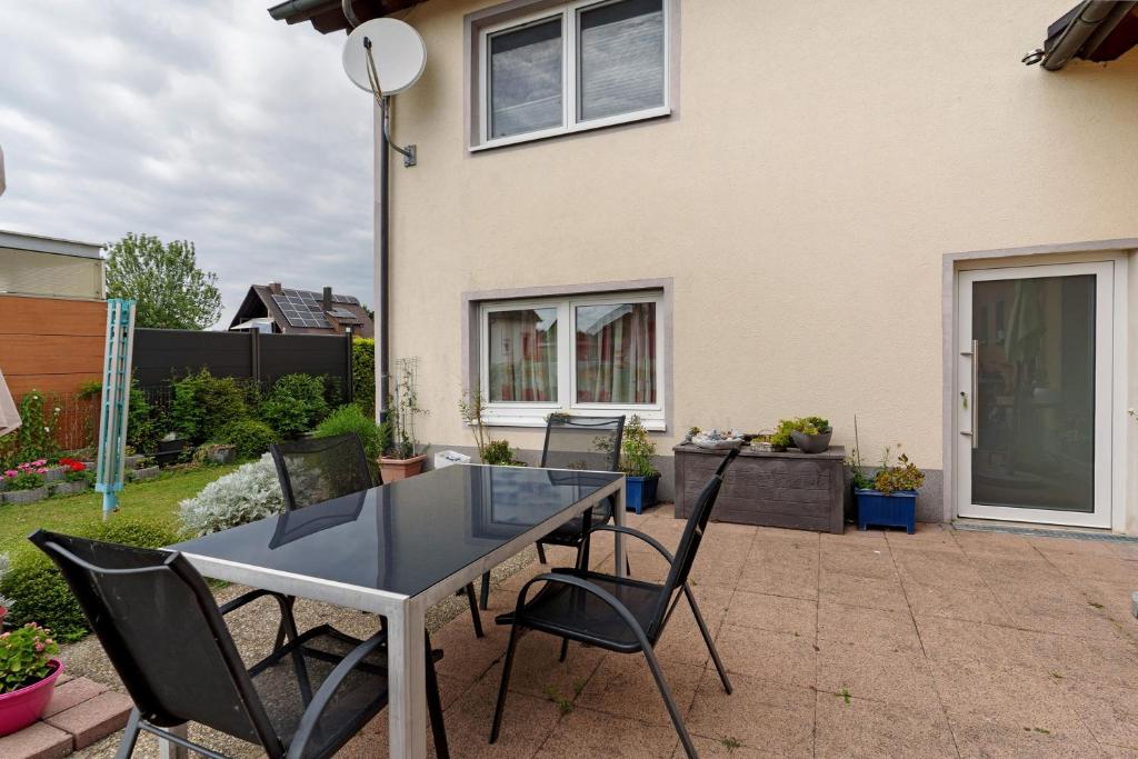 a table and chairs in the backyard of a house at Nichtraucher-Ferienwohnung Sandhaas in Ringsheim