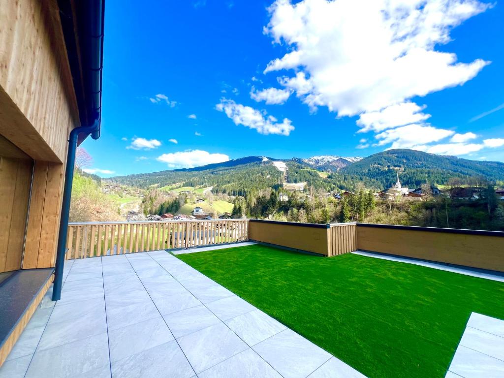 a balcony with green grass and mountains in the background at Haus Heimat Wagrain in Wagrain