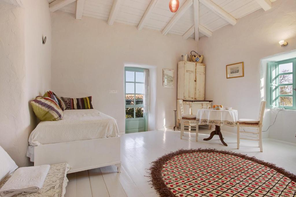 a white bedroom with a bed and a table at Sira Stonehouse lll in Volímai