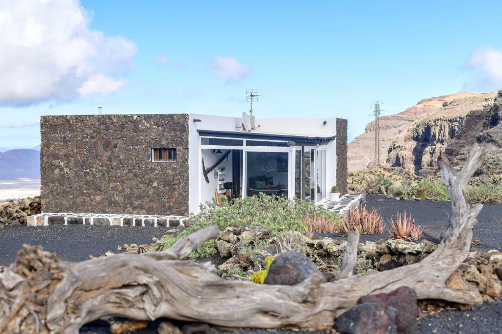 a house with a tree trunk in front of it at Casa Vereda del Risco in Ye
