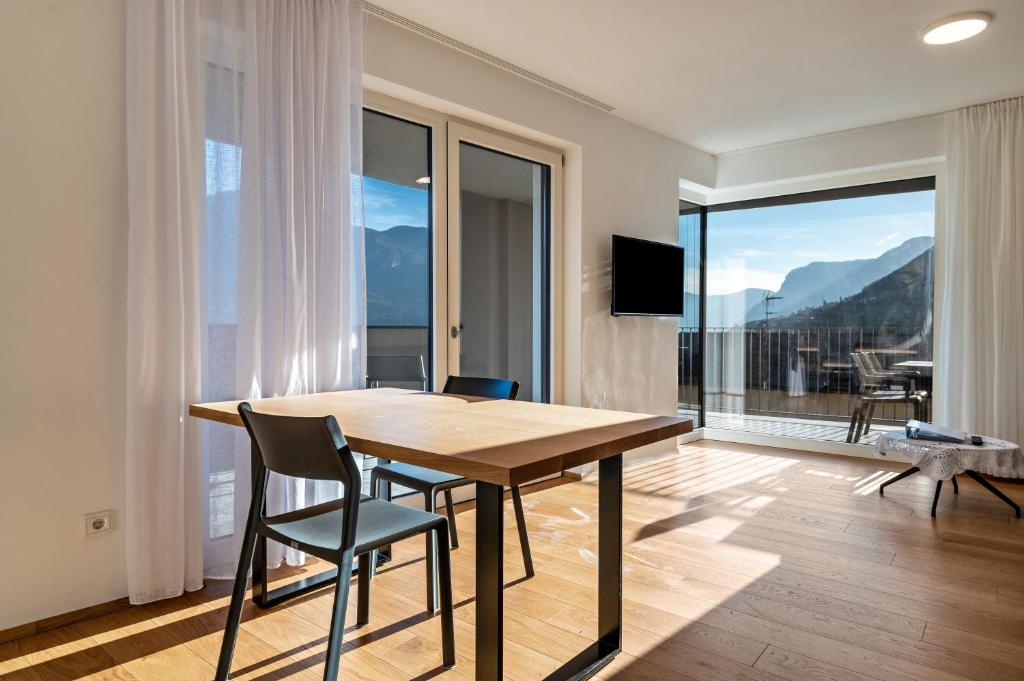 a dining room with a table and chairs and a balcony at Ferienwohnungen Karin - Lagrein in Termeno