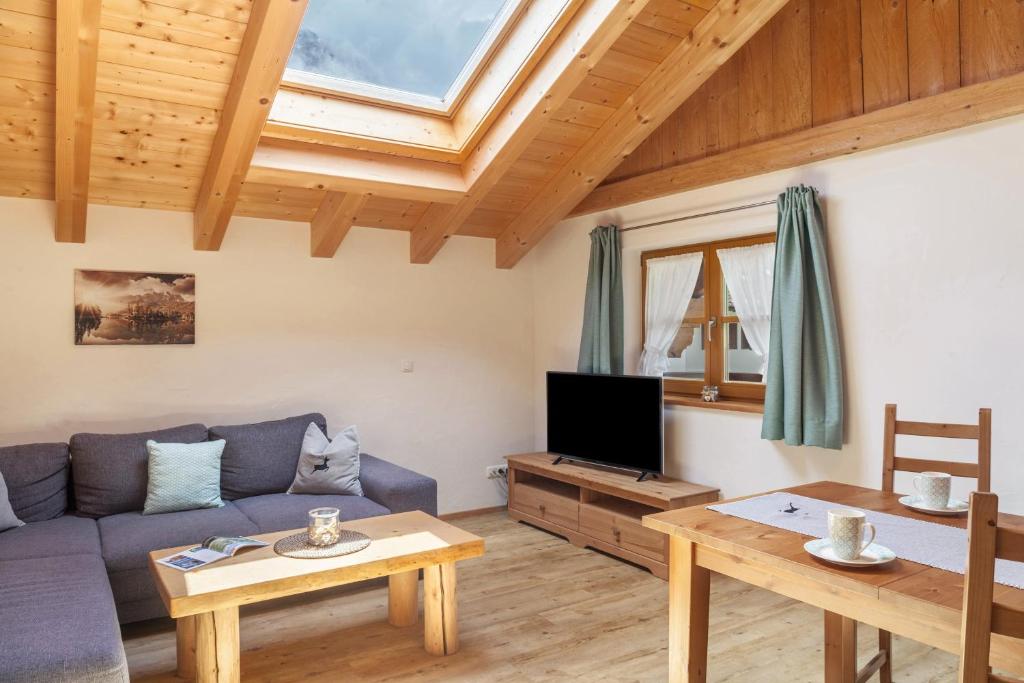 a living room with a couch and a tv at Apartment Ferienhaus Huber in Grainau