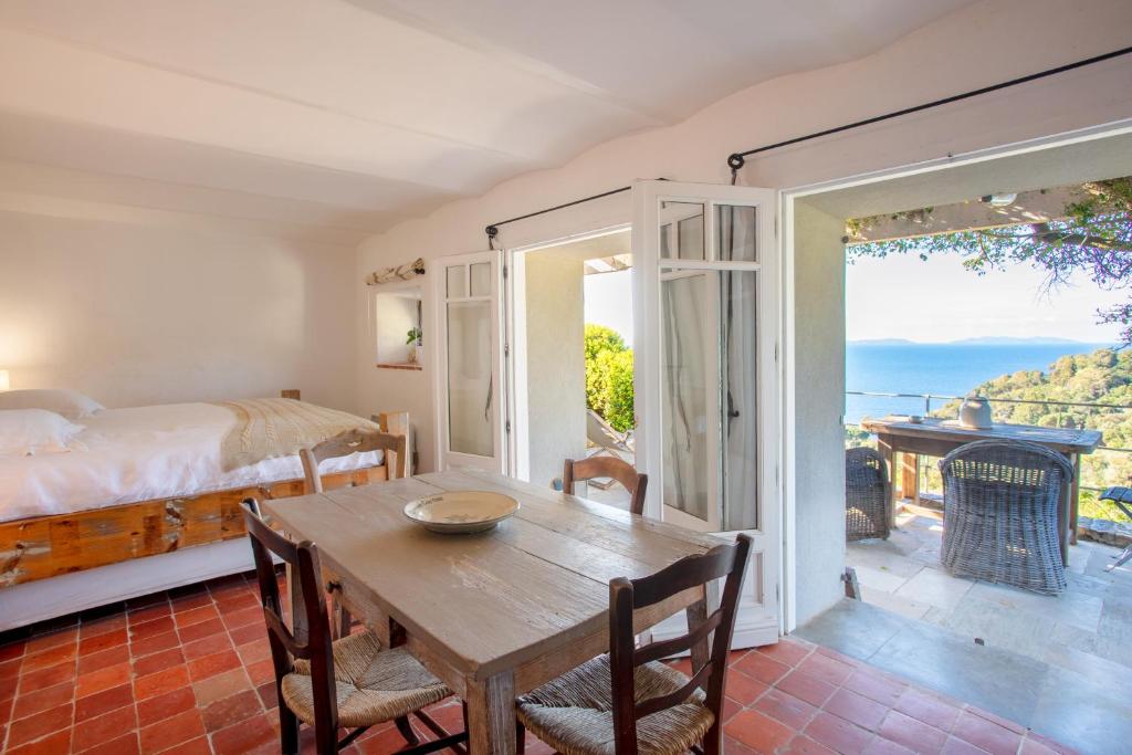 a bedroom with a table and a bed and a balcony at La Maison de Constance in Cavalaire-sur-Mer