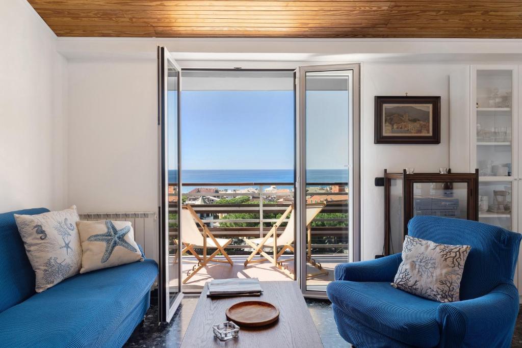 a living room with blue couches and a view of the ocean at Attico Con Vista in Moneglia