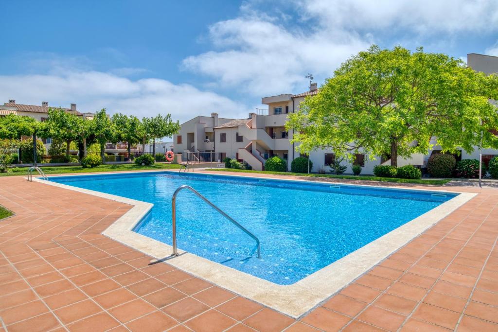 a swimming pool in a yard with trees and buildings at Apartament a Sant Antoni de Calonge in Calonge