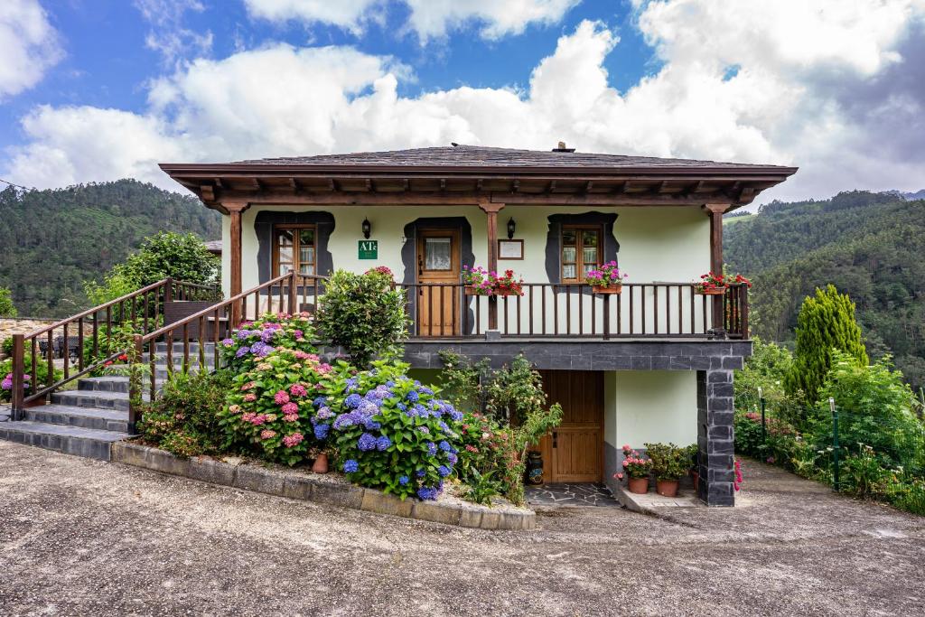 a small house with a balcony and flowers at Maseda 1 in Villayón