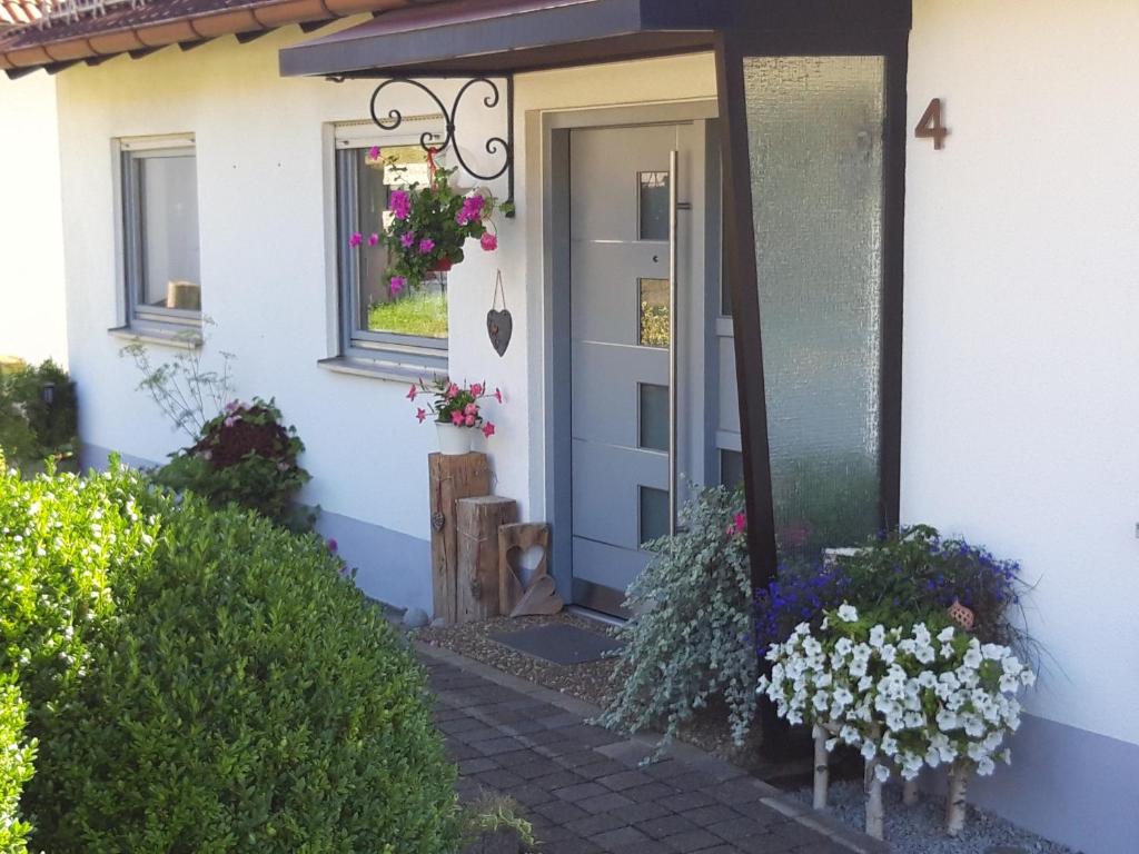 a front door of a white house with flowers at Schwäbische Alb in Gomadingen