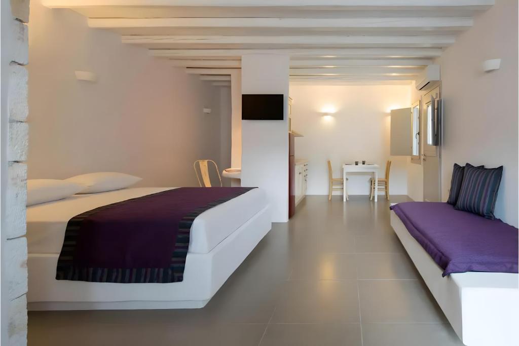 a bedroom with a large bed and a table at Echinousa Kimolos katoikia no2 in Kimolos