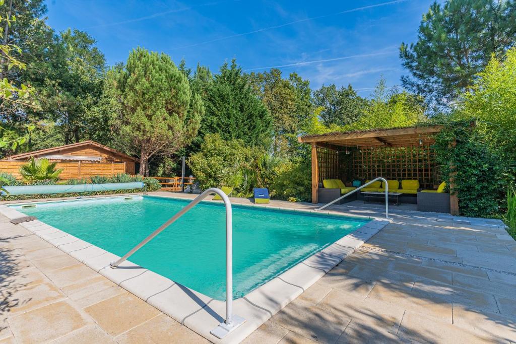 a swimming pool in the backyard of a home at La maisonnette en bois in Saumos