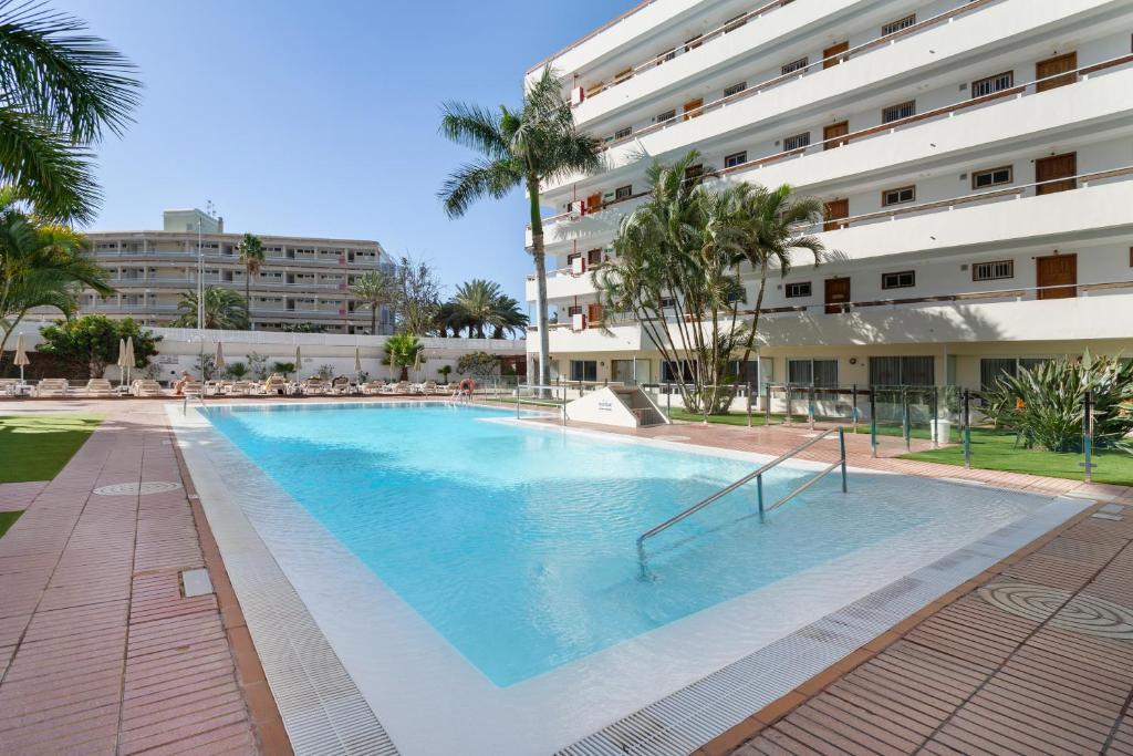 a large swimming pool in front of a building at Kellys' Apartment Las Camelias in San Bartolomé