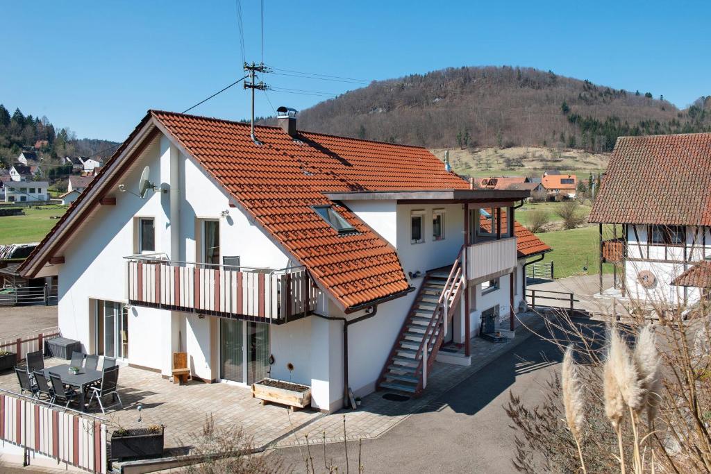 a white house with an orange roof at Albpartments in Meßstetten