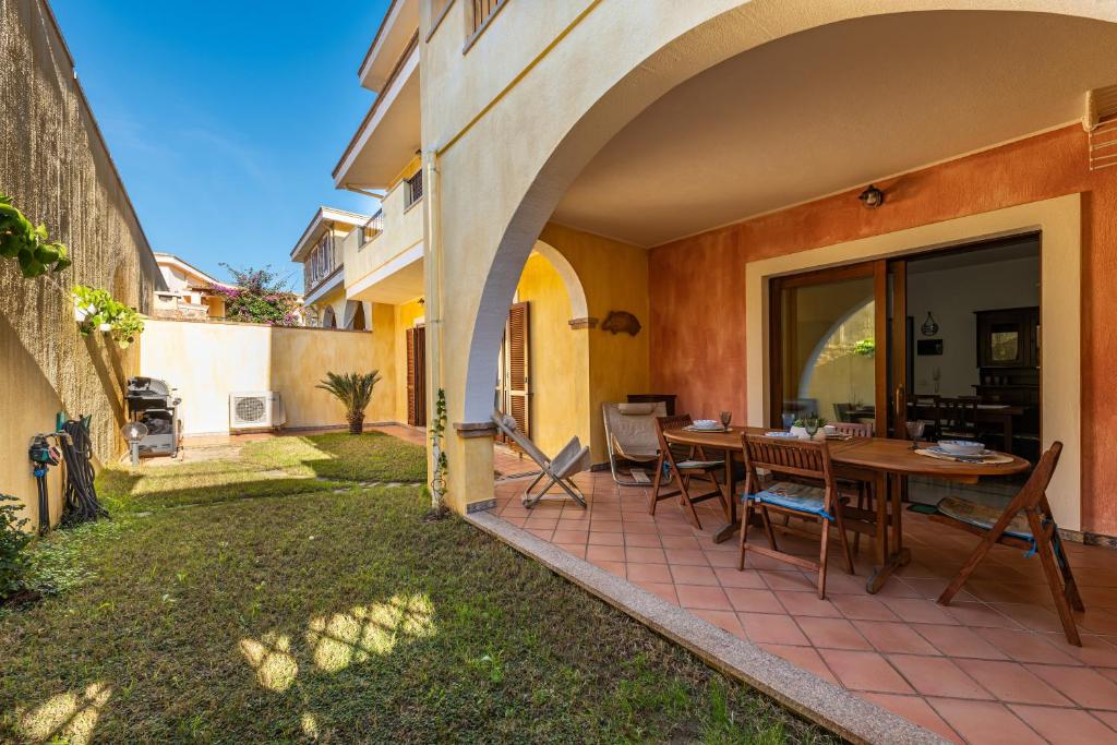 an outdoor patio with a wooden table and chairs at Casa Celeste in Villasimius