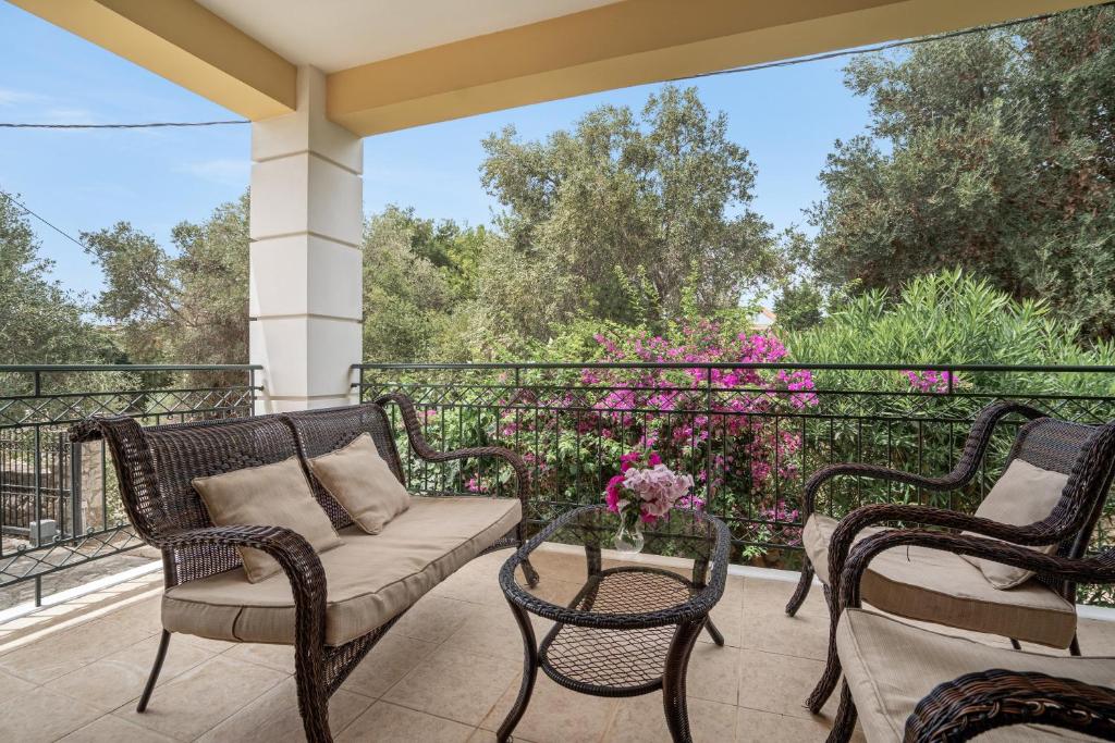 a porch with two chairs and a couch and a table at Casa Miranda in Kefallonia