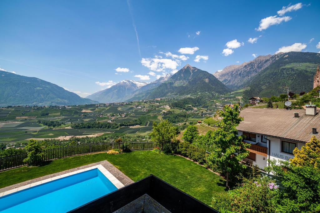 a view of the mountains from a house with a swimming pool at Gartenheim App Josef in Schenna