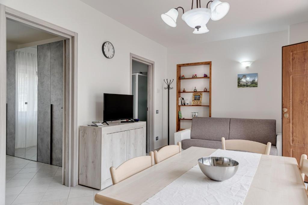 a living room with a table and a television at Chalet La Greta con vista in Firenzuola