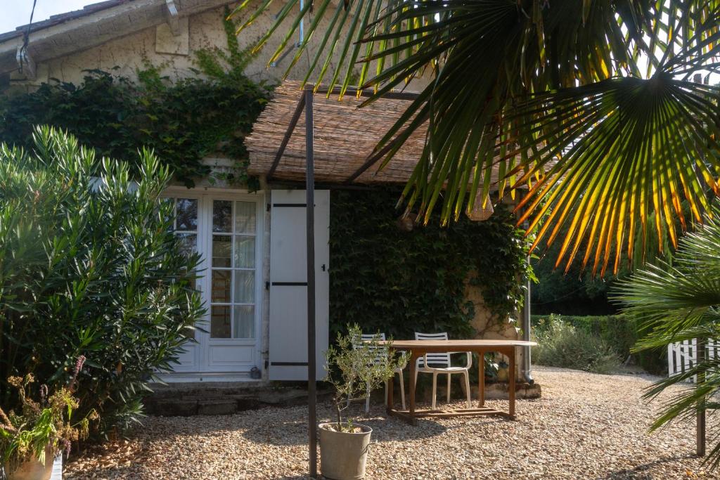 a house with a table and chairs in front of it at Villa au bord de la Charente in Jarnac