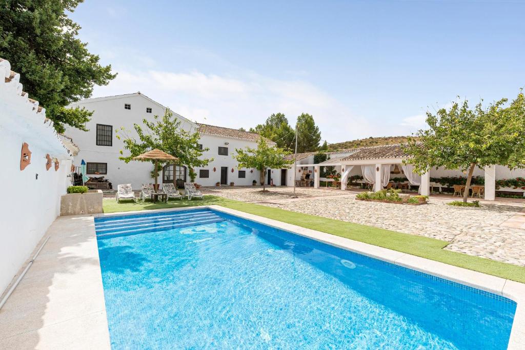 a swimming pool in the backyard of a house at Cortijo Caracate in Archidona