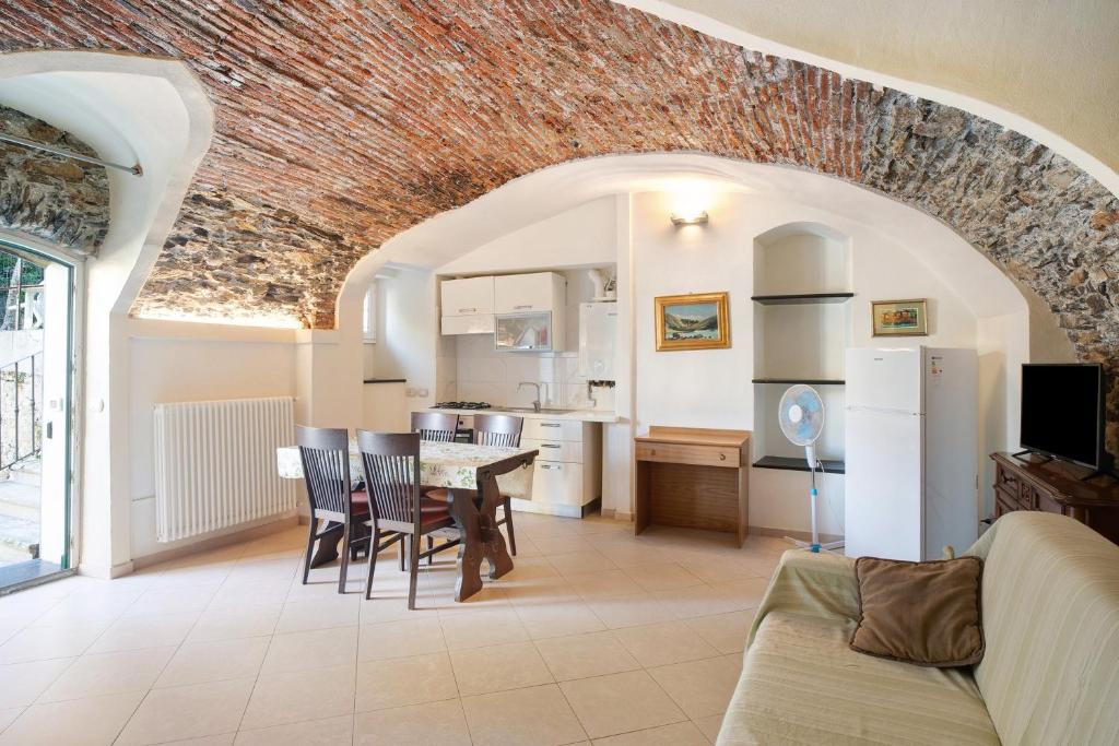 a kitchen and living room with a table and chairs at Le scale, borgo dei pescatori in Cervo