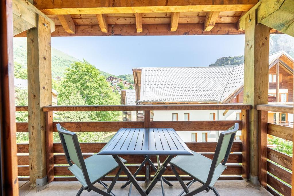 a table and chairs on a balcony with a view at Appartement C21 in Valloire