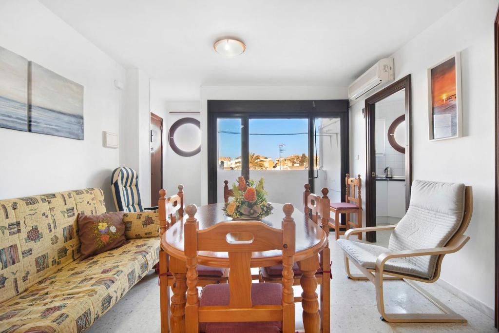 a living room with a couch and a table and chairs at Sol y mar in Sanlúcar de Barrameda