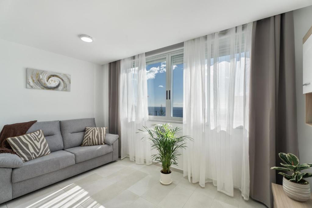 a living room with a couch and a large window at Apartamento Iris Tropical in Araya