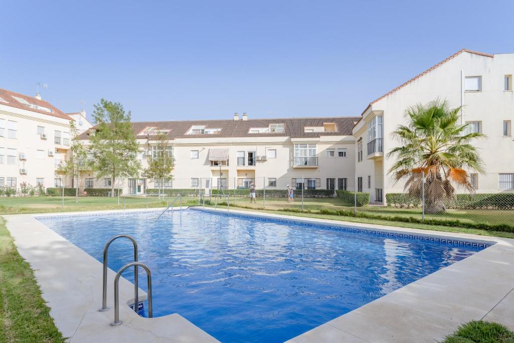 a swimming pool in front of two apartment buildings at Villa Gallardo in Campillos