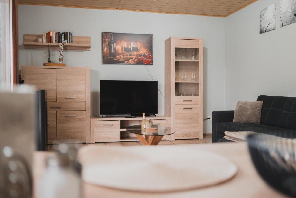 a living room with a couch and a television at Ferienwohnungen Bullau - 2 in Erbach
