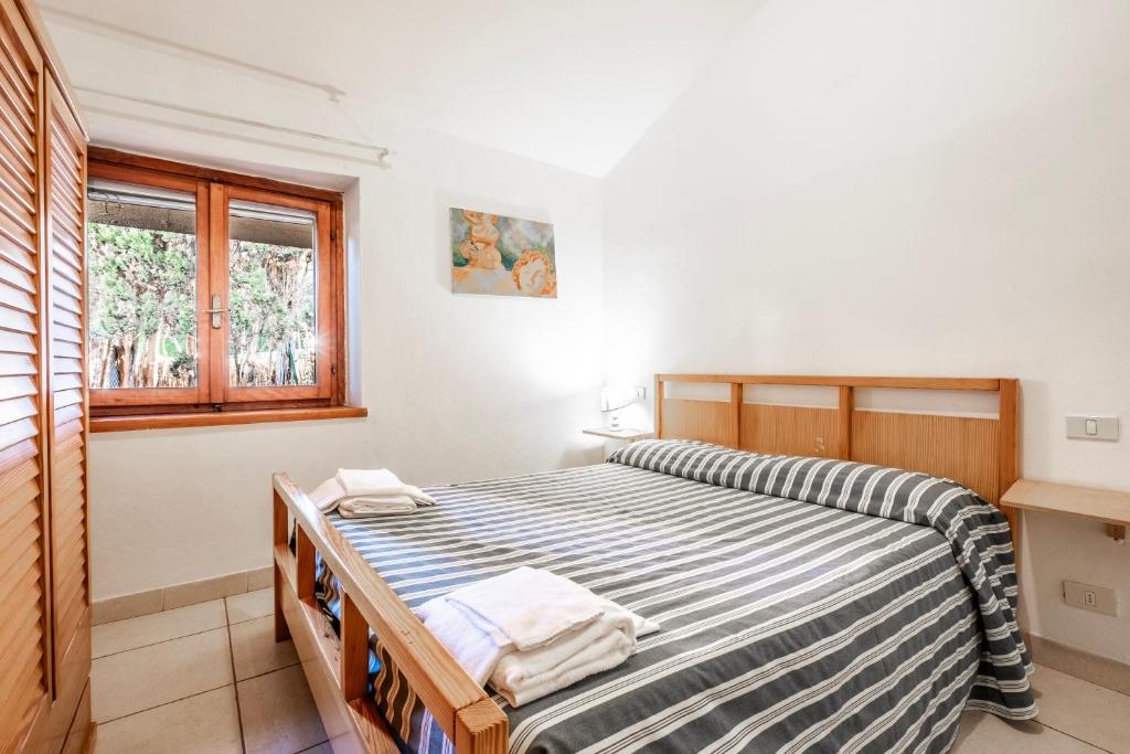 a bedroom with a bed and a window at La Capannuccia C in Ansedónia