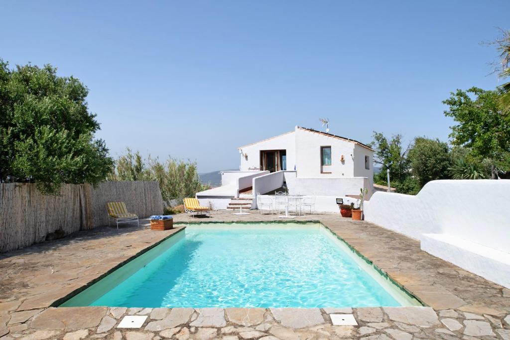 a villa with a swimming pool in front of a house at Casa De Los Pintores Facinas in Facinas