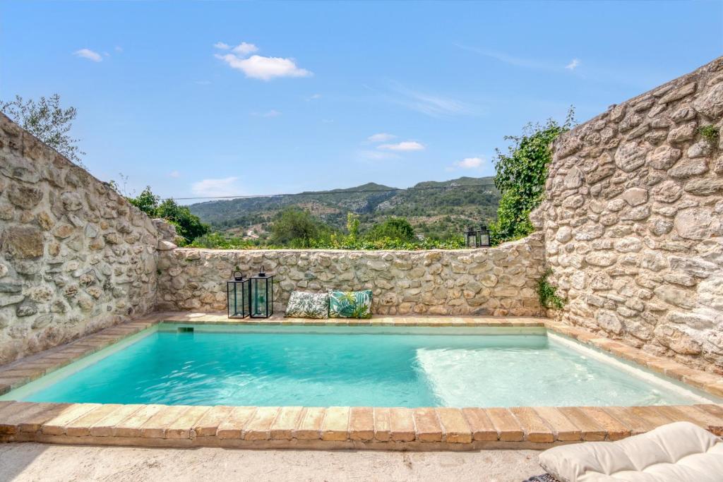 a large swimming pool in a stone wall at Ca la Pasita 28 in Beniali
