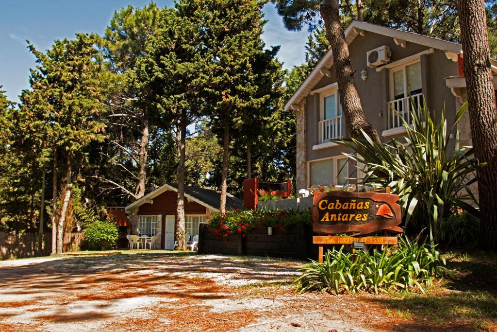 una casa con un cartel frente a una entrada en Cabañas Antares en Mar de las Pampas