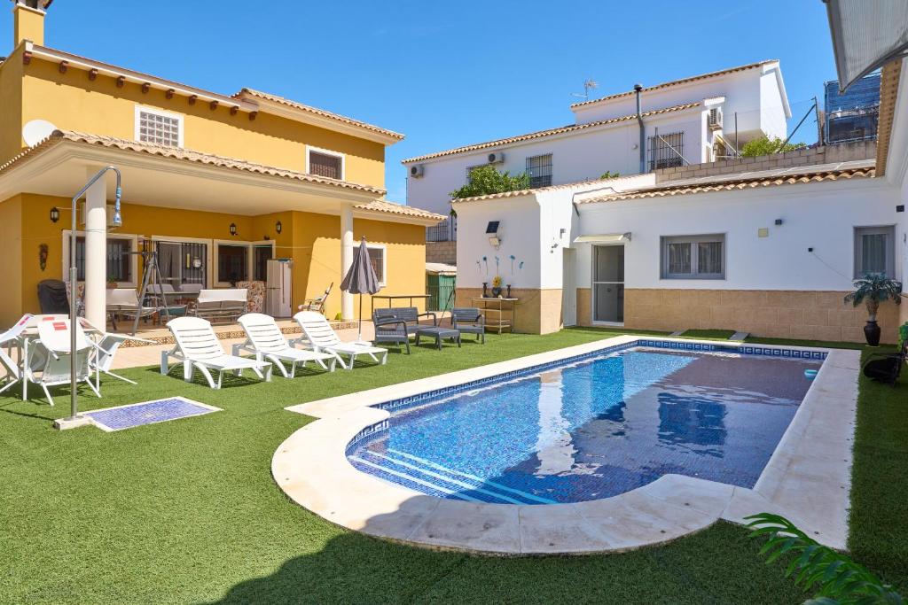 a backyard with a swimming pool and a house at Marisol' House in Puente Genil