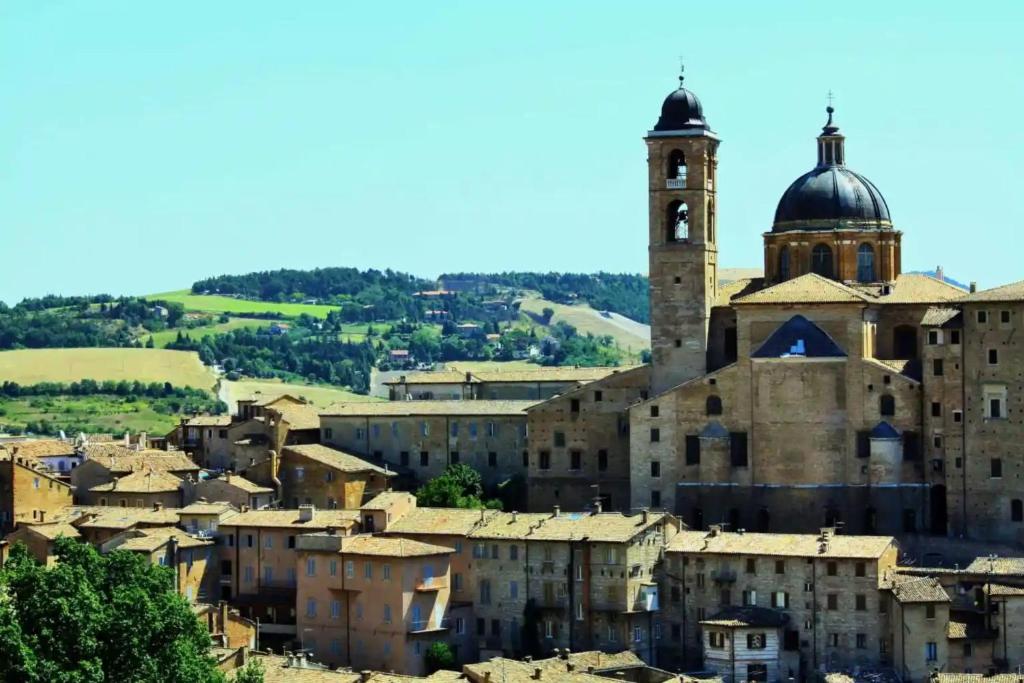 a city with a church and a clock tower at Elena's Guest House in Urbino