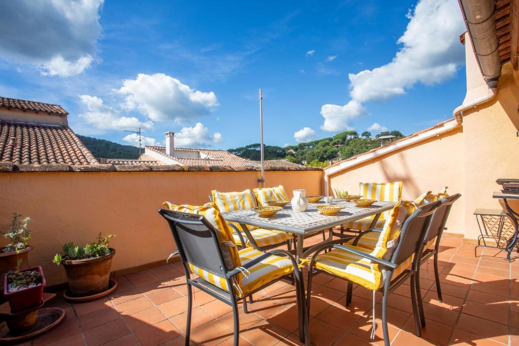 a patio with a table and chairs on a balcony at Maison Collo in Collobrières