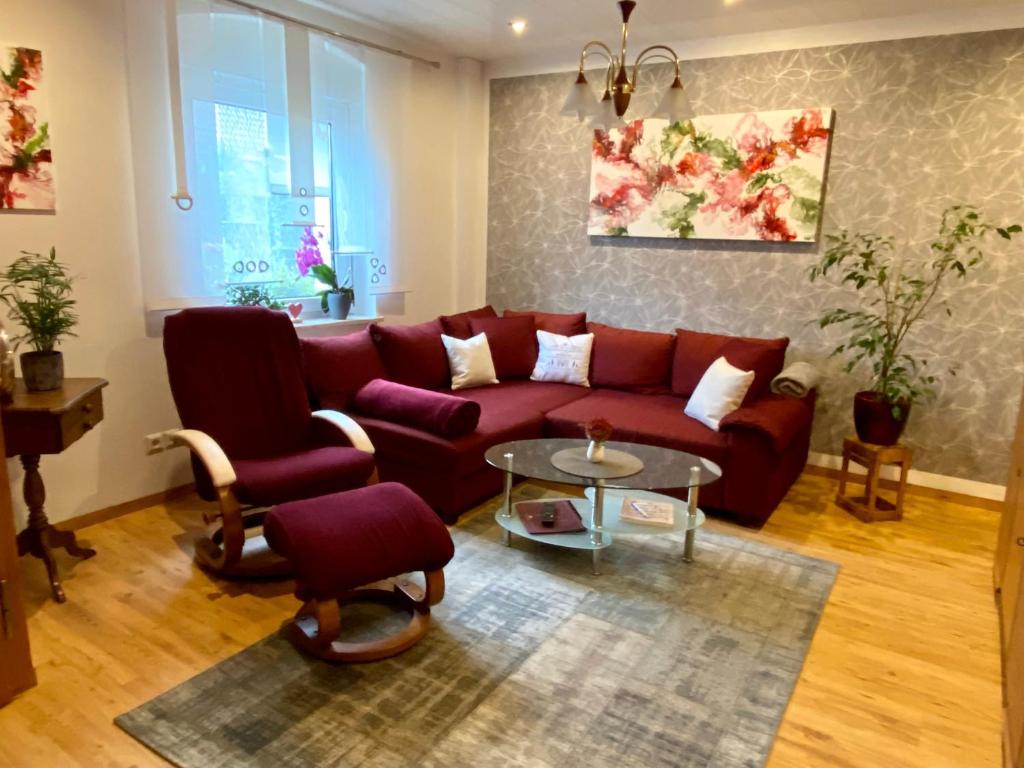 a living room with a red couch and a table at Haus Steffine in Annahütte