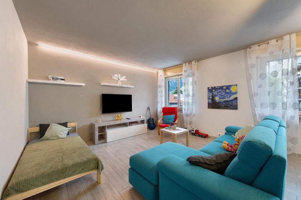 a living room with a blue couch and a tv at Residenza Tambella in Verrès