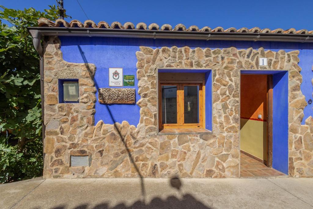 a blue building with two windows and a door at El Alarife in Sediles