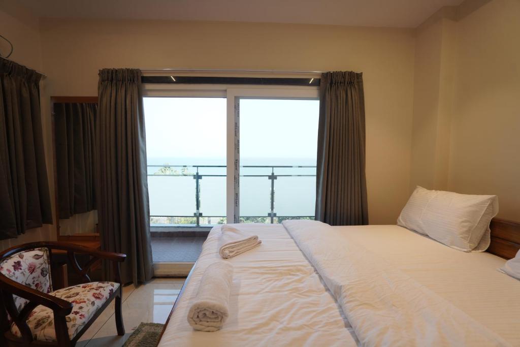 a bedroom with a bed and a large window at v square inn in Visakhapatnam