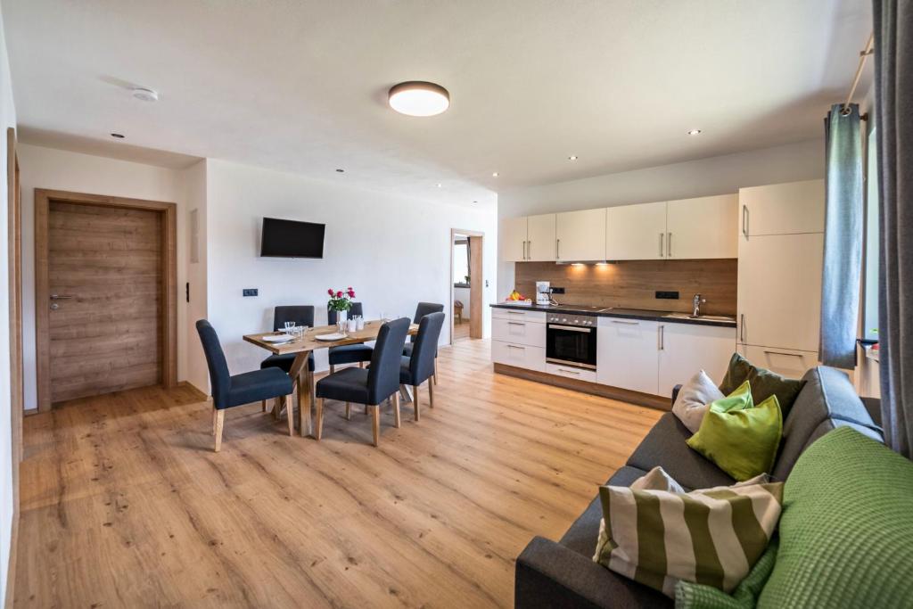 a living room and kitchen with a table and chairs at Ferienwohnung am Mühlbachl in Rohrberg