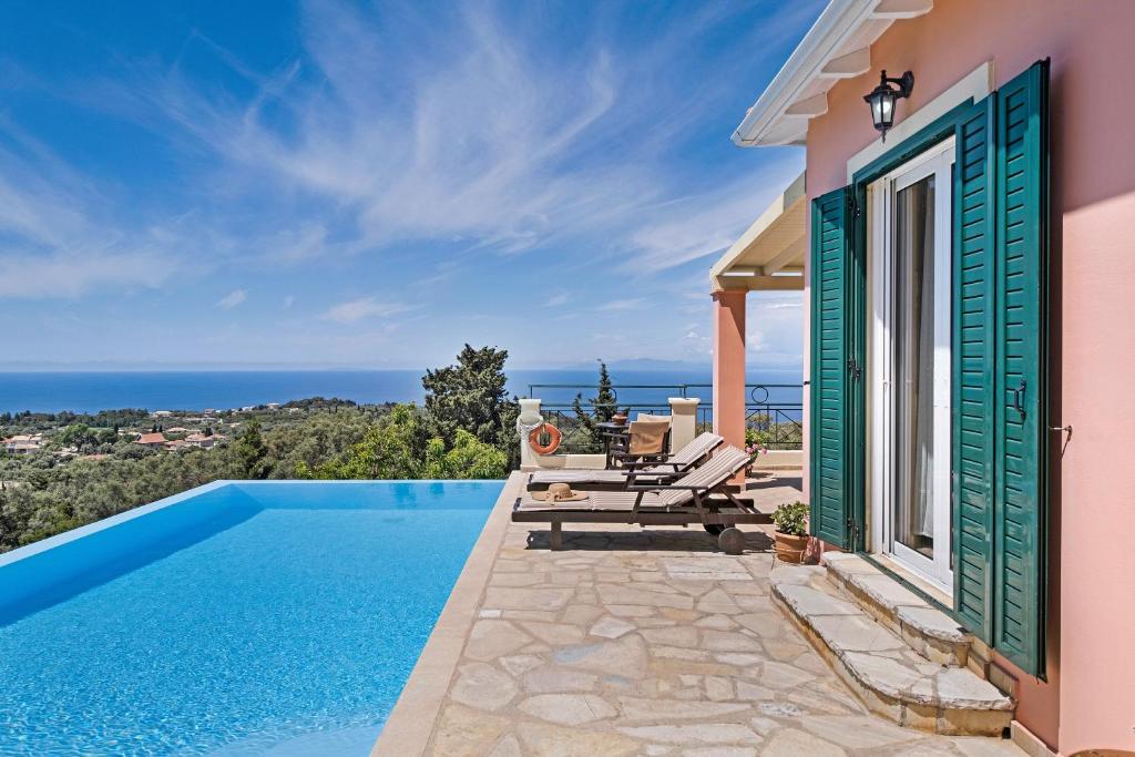 a villa with a swimming pool with a view of the ocean at Villa Belvedere Rosa in Lefkada