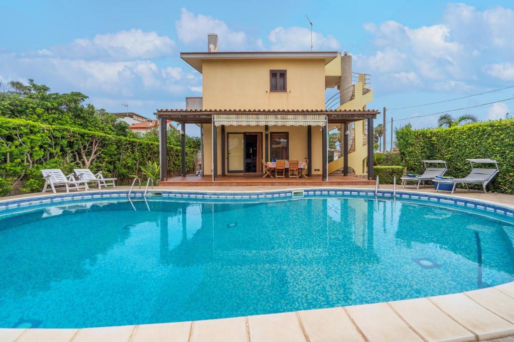 a large swimming pool in front of a house at Villa Raffa in Avola