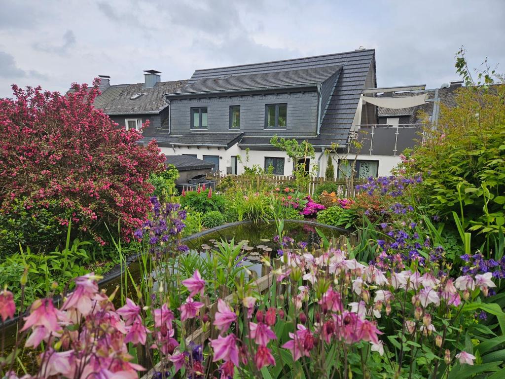 a garden with flowers in front of a house at Ferienwohnung Haus Luise in Olsberg