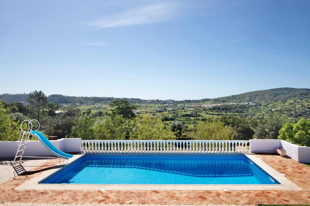 a swimming pool with a swing and a swimming pool at Casa Noah in São Bartolomeu de Messines
