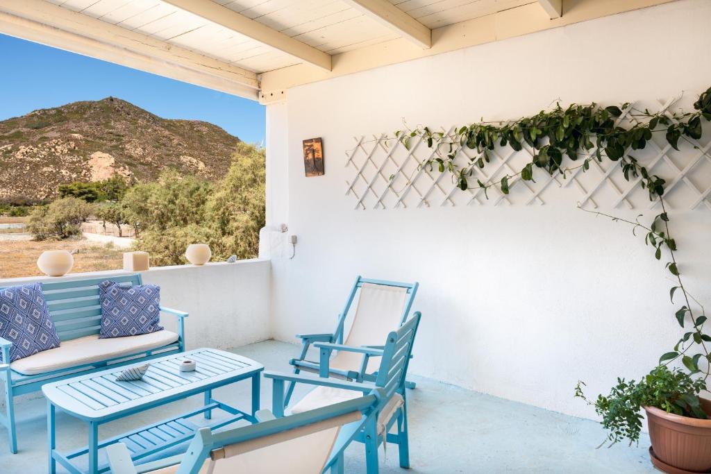 a porch with two blue chairs and a table at Beachfront Lampis Dolphin 1 in Skala